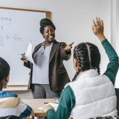 professora responde pergunta de aluna em sala de aula